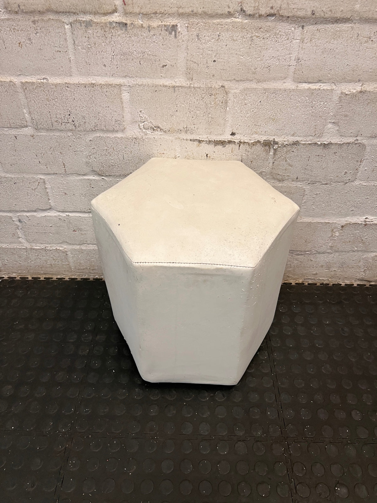 White Hexagonal Upholstered Ottoman — Aged Upholstery with Visible Wear – condition detail