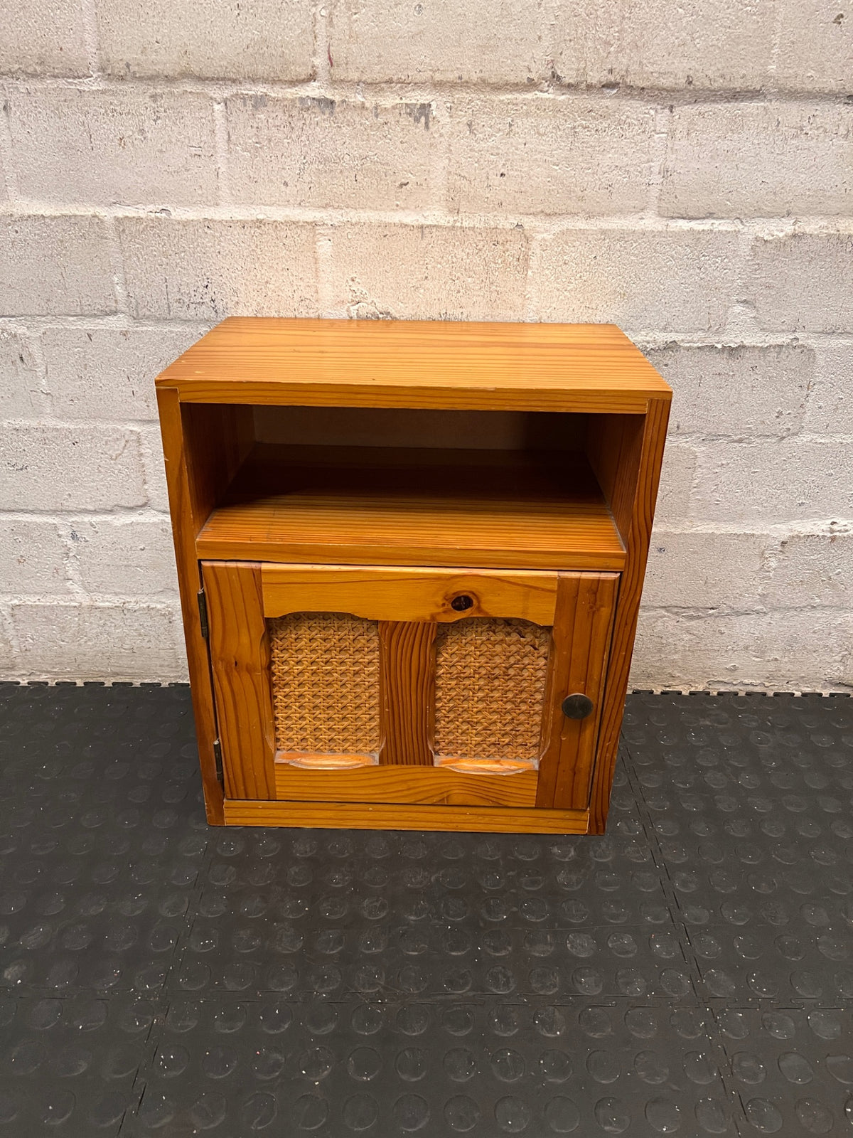 Wooden Bedside Table with Rattan-Style Door Insert — Fair Condition With Visible Wear – main front view