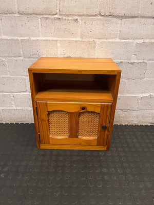 Wooden Bedside Table with Rattan-Style Door Insert — Fair Condition With Visible Wear – main front view