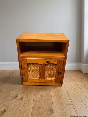 Wooden Bedside Table with Rattan-Style Door Insert — Fair Condition With Visible Wear – styled product image