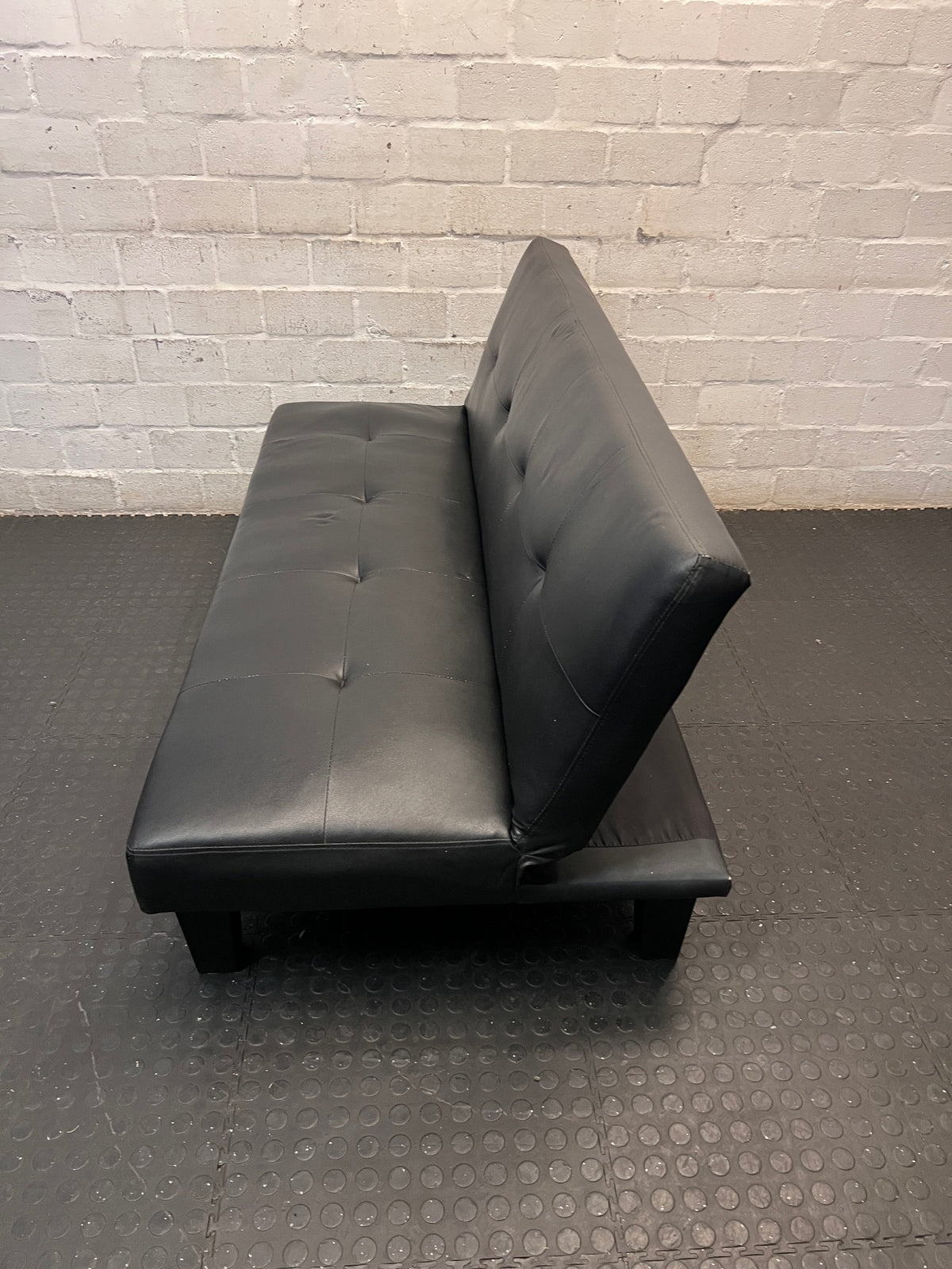 Black Tufted Leather-Look Sleeper Couch — Good Working Order – side view