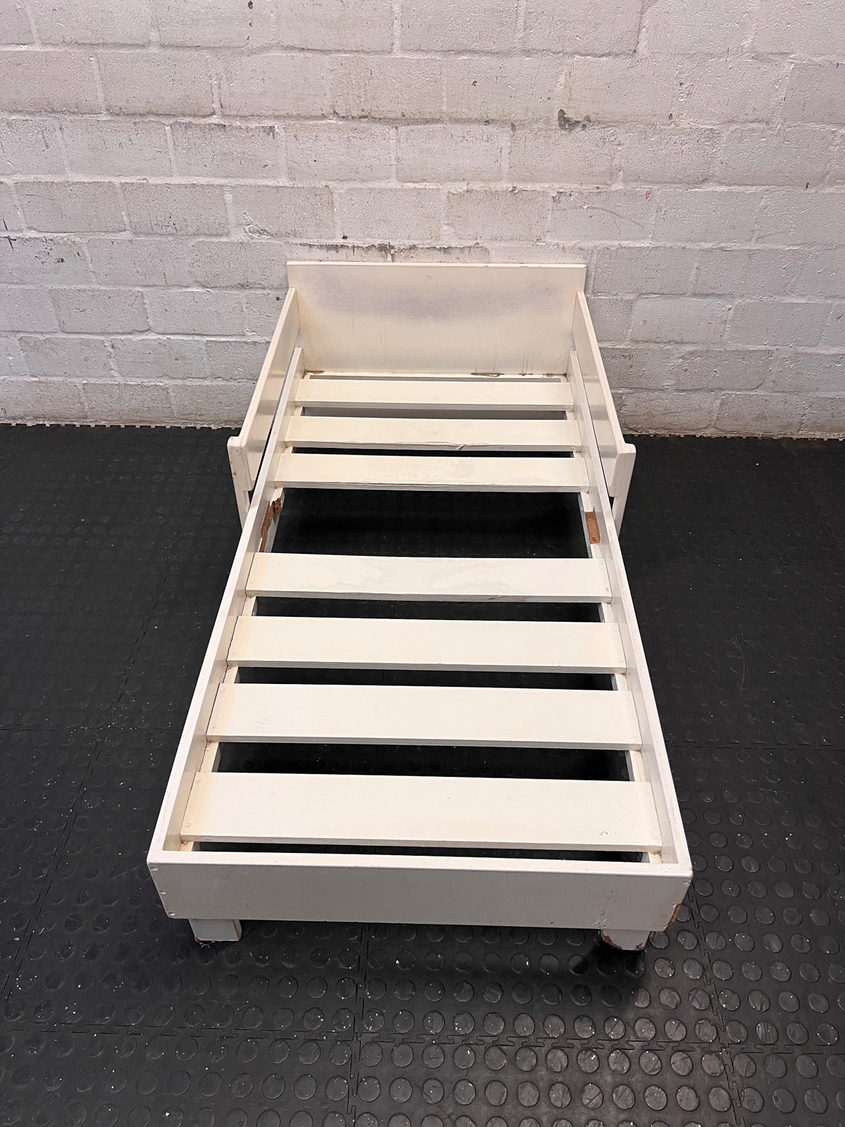 White Wooden Toddler Bed Frame with Slatted Base — Significant Wear and Missing Slats – main front view