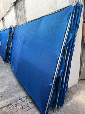 Blue shade-cloth fence divider panels stacked
