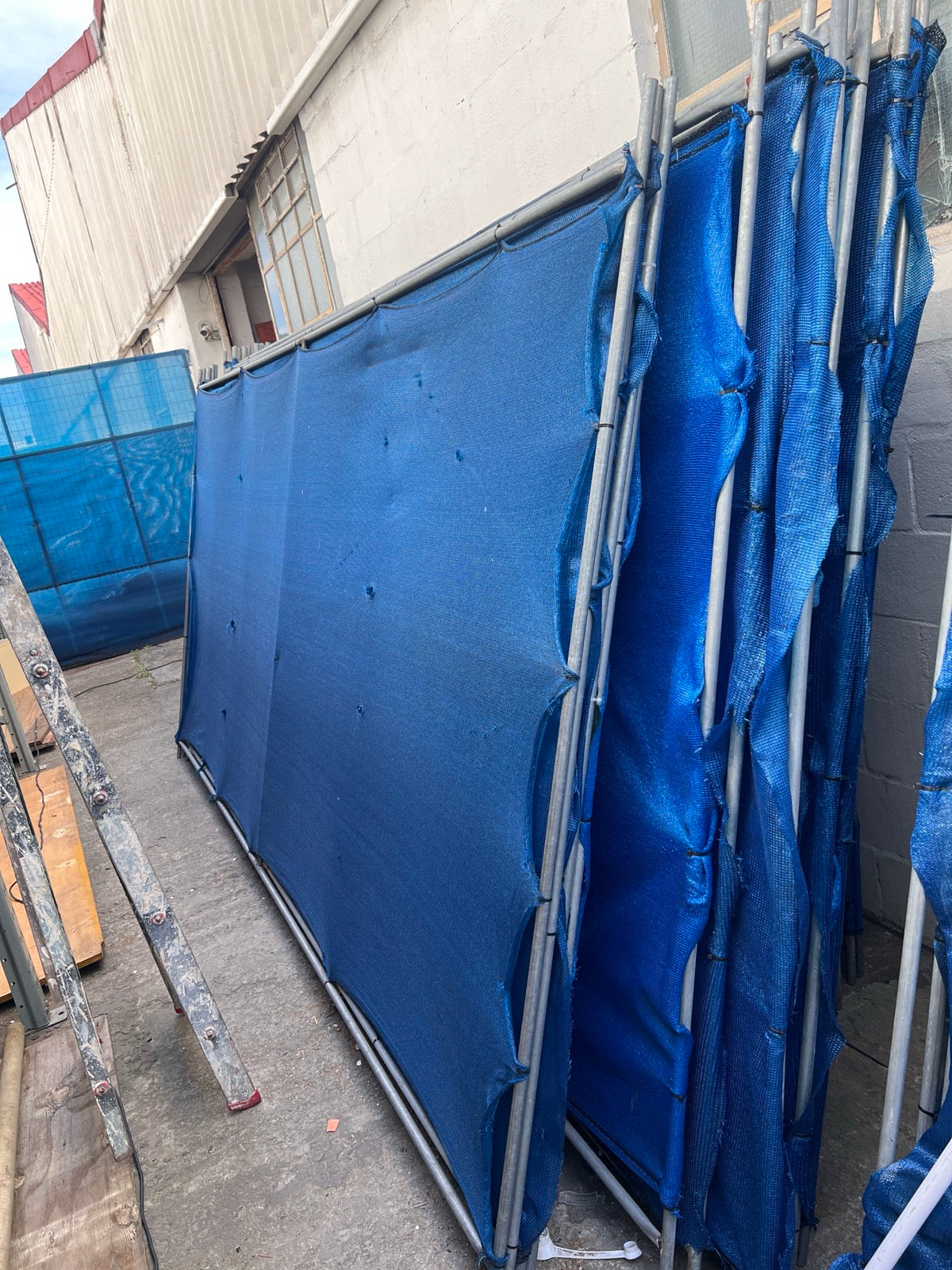 Blue shade-cloth fence divider panels side view