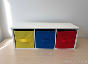 White storage bench with three colorful fabric bins on a wooden surface.