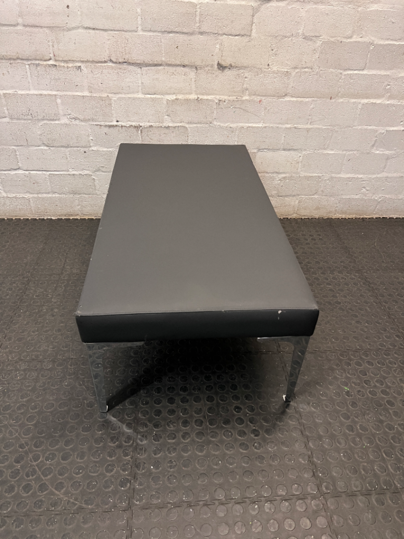 Black Upholstered Bench with Chrome Legs — Fair Condition with Visible Wear