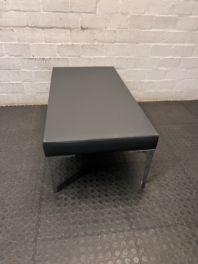Black Upholstered Bench with Chrome Legs — Fair Condition with Visible Wear
