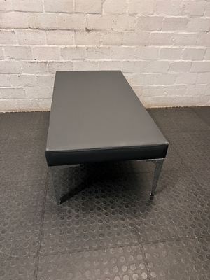 Black Upholstered Bench with Chrome Legs — Fair Condition with Visible Wear