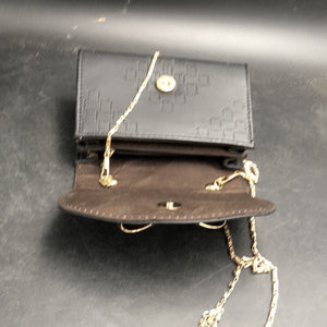 Black small handbag with a gold chain
